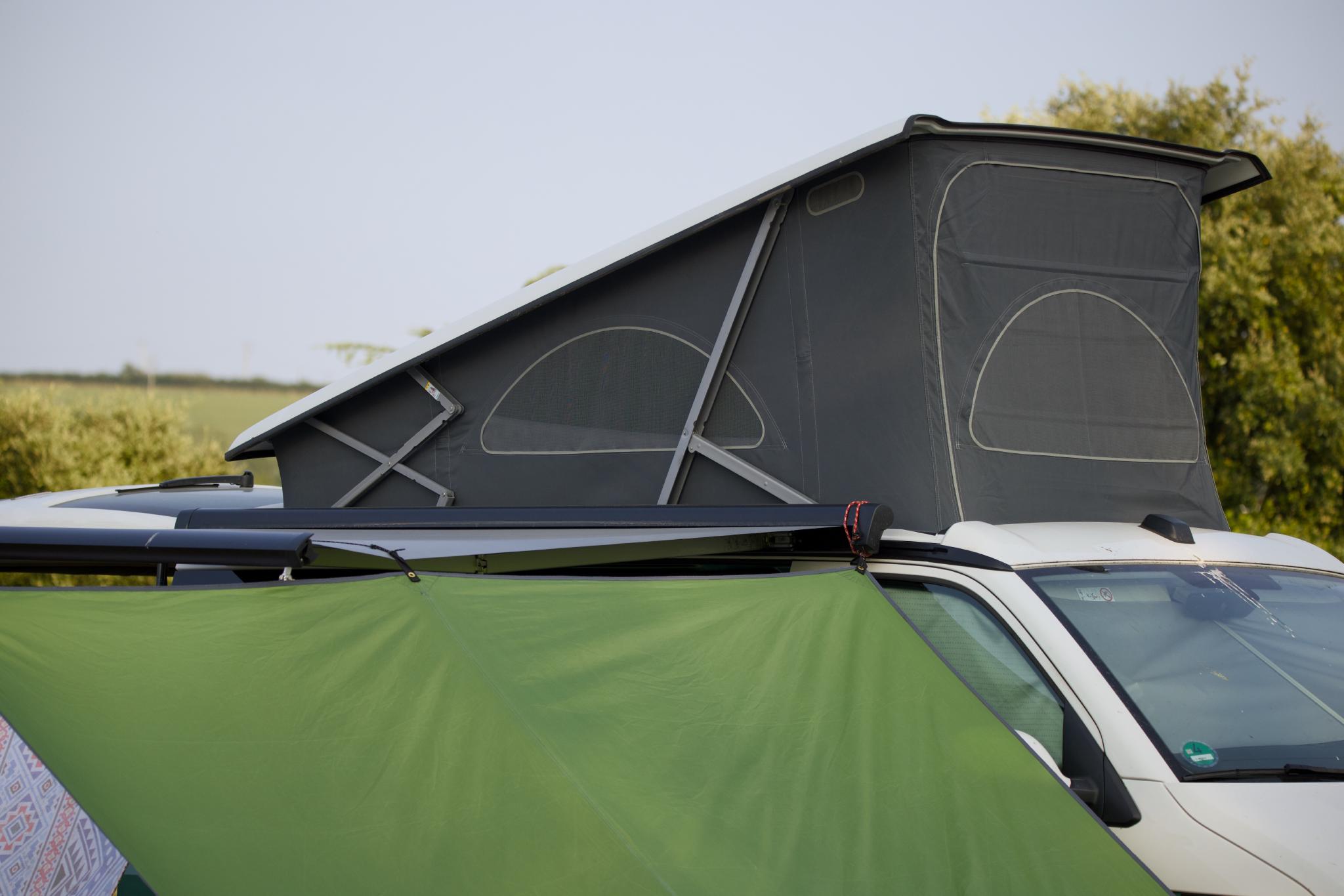The California's pop-up roof behind the green awning tent