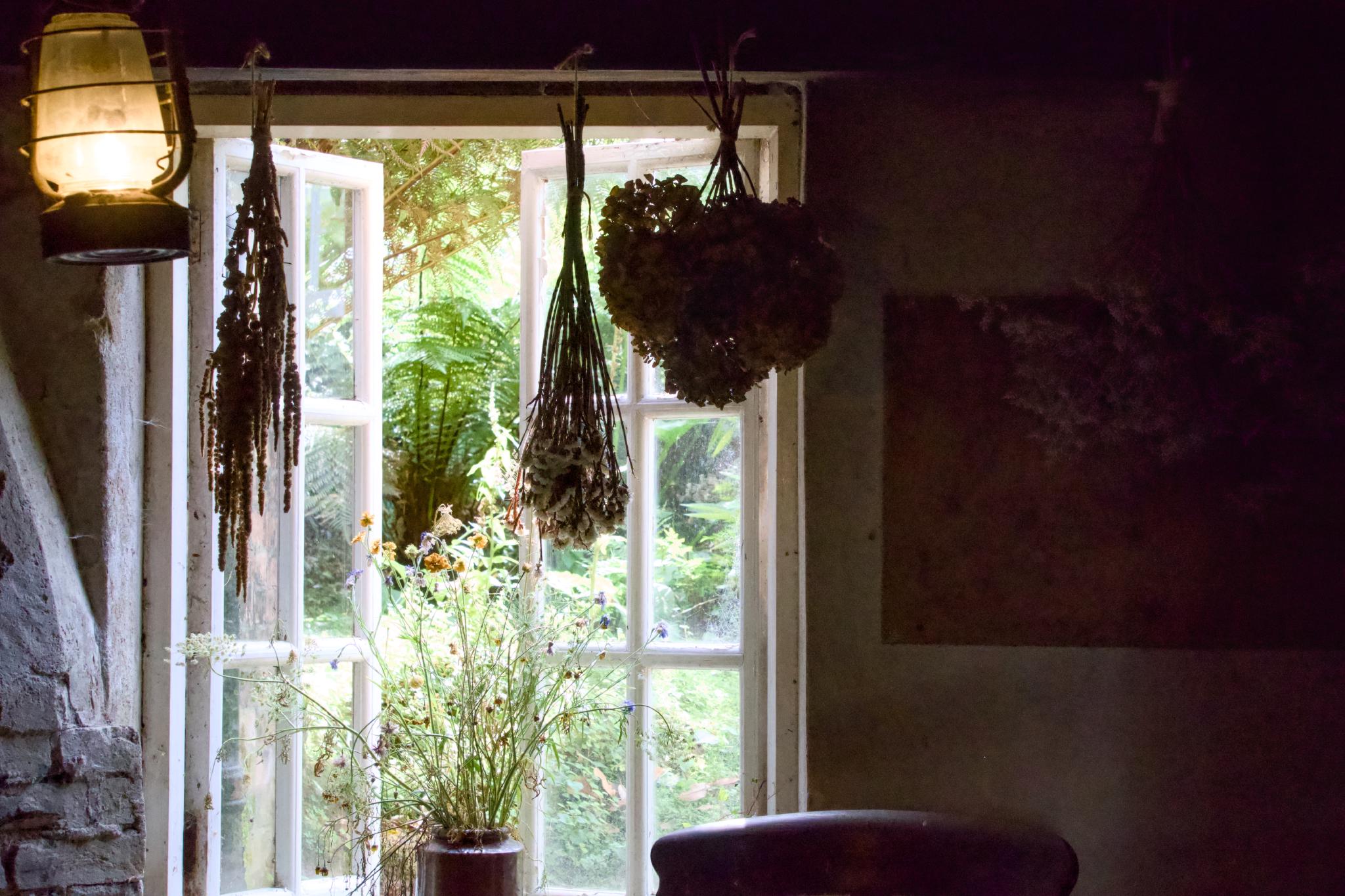 Potting shed window with an oil lamp and dried flowers