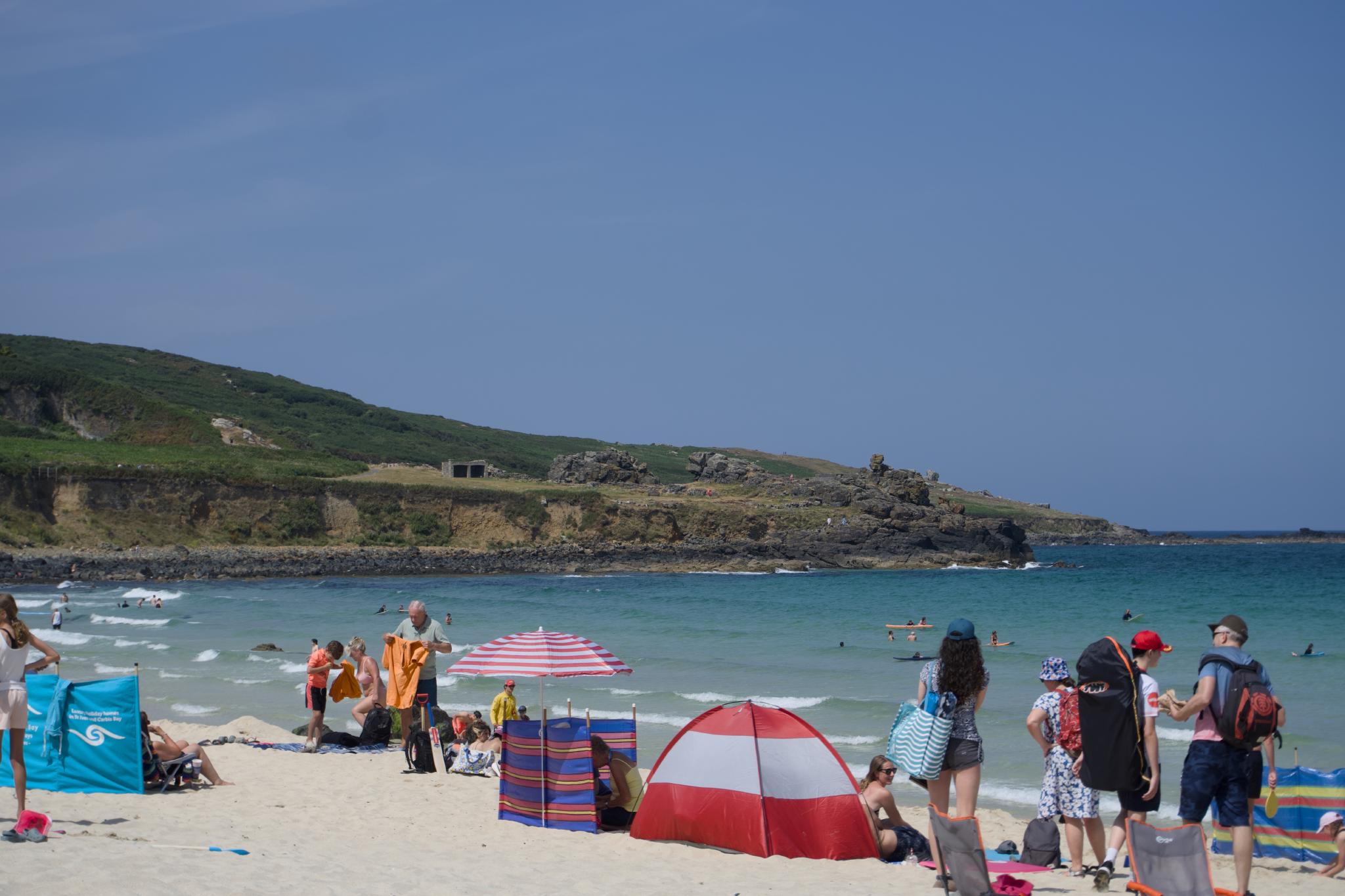 Busy beach in St Ives with a green headland behind