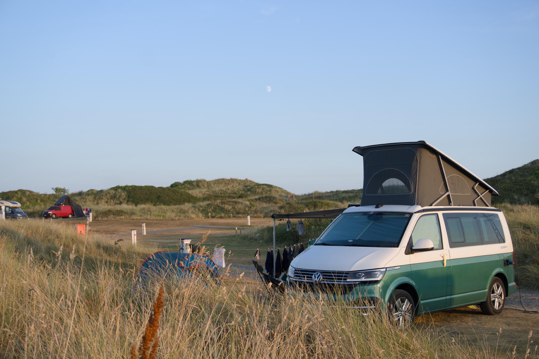 The California with the roof up on the pitch between the dunes, the moon above