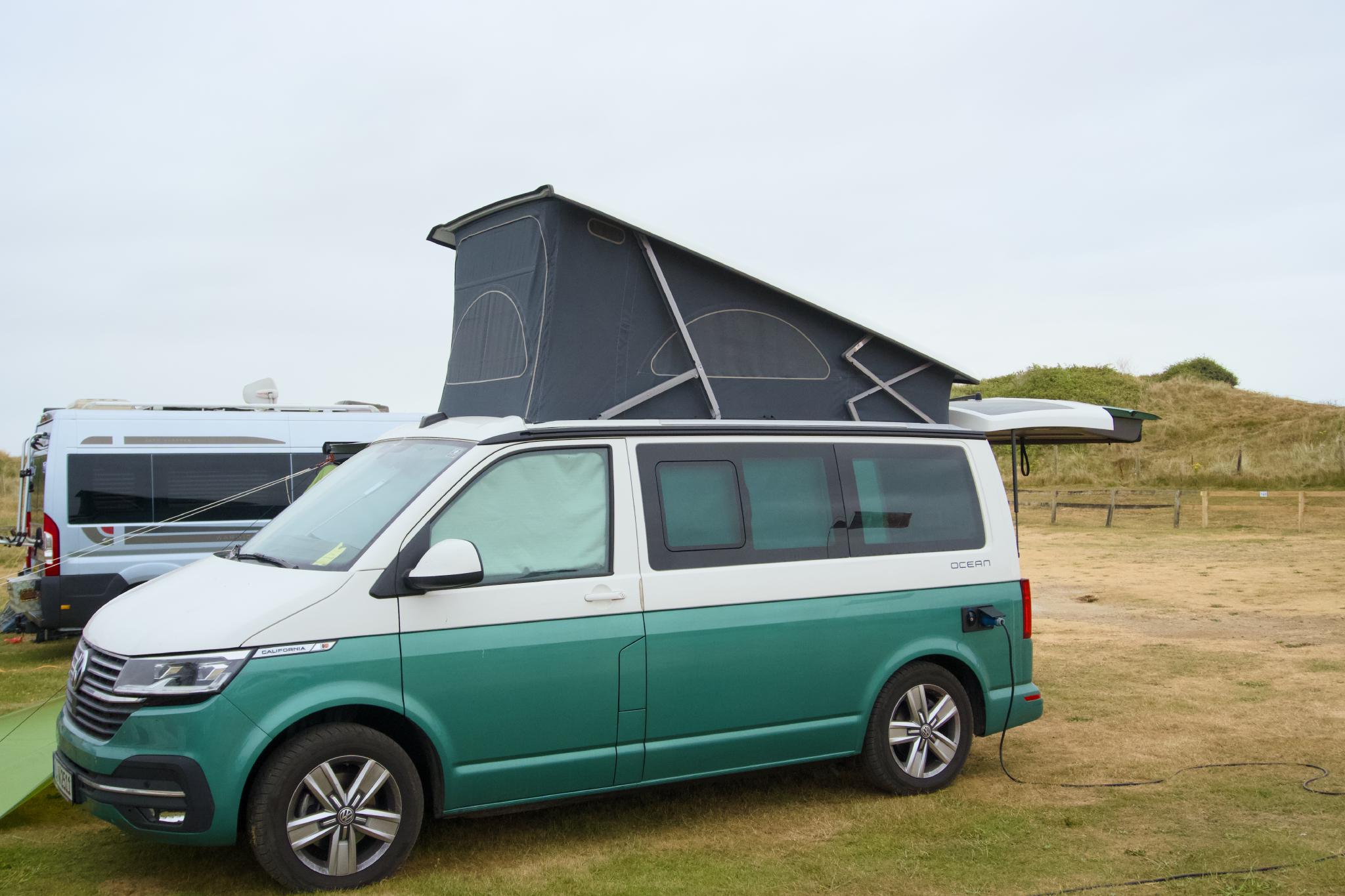 The California with the roof up on the pitch, dunes behind
