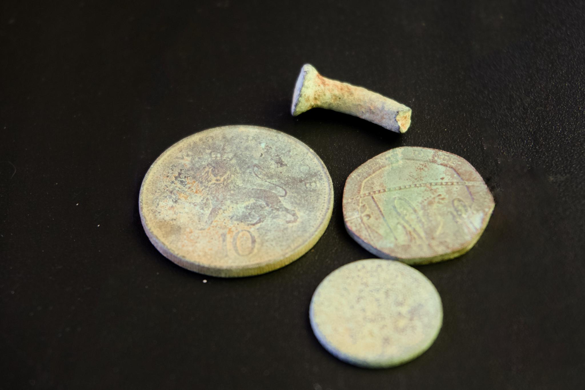 Corroded coins and an old nail