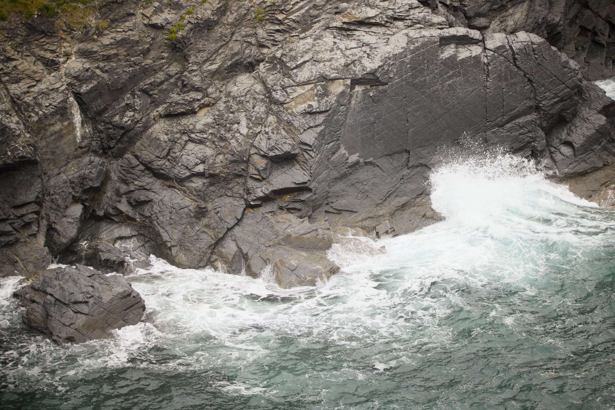 Wave breaking on the rocks below the cliff