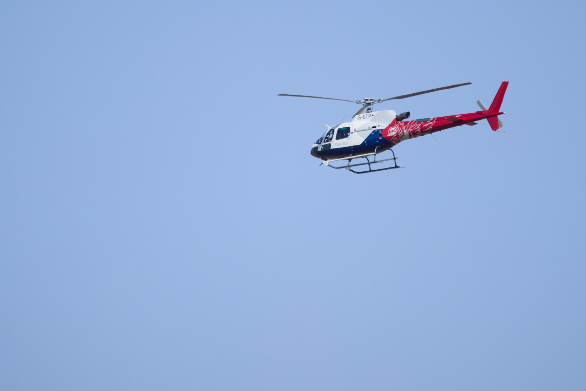 QinetiQ helicopter in flight against a blue sky