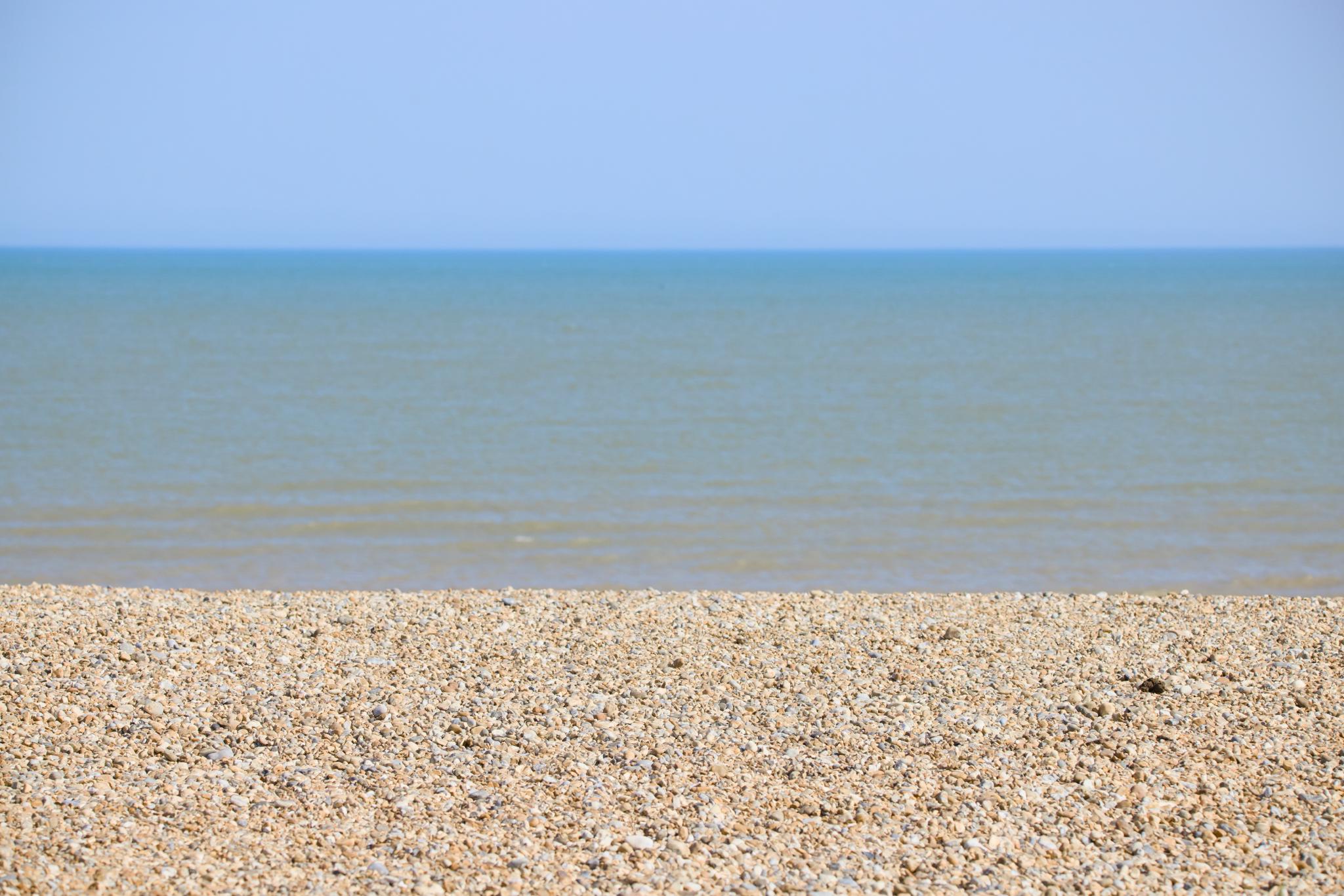 Shingle beach and the sea under a clear sky