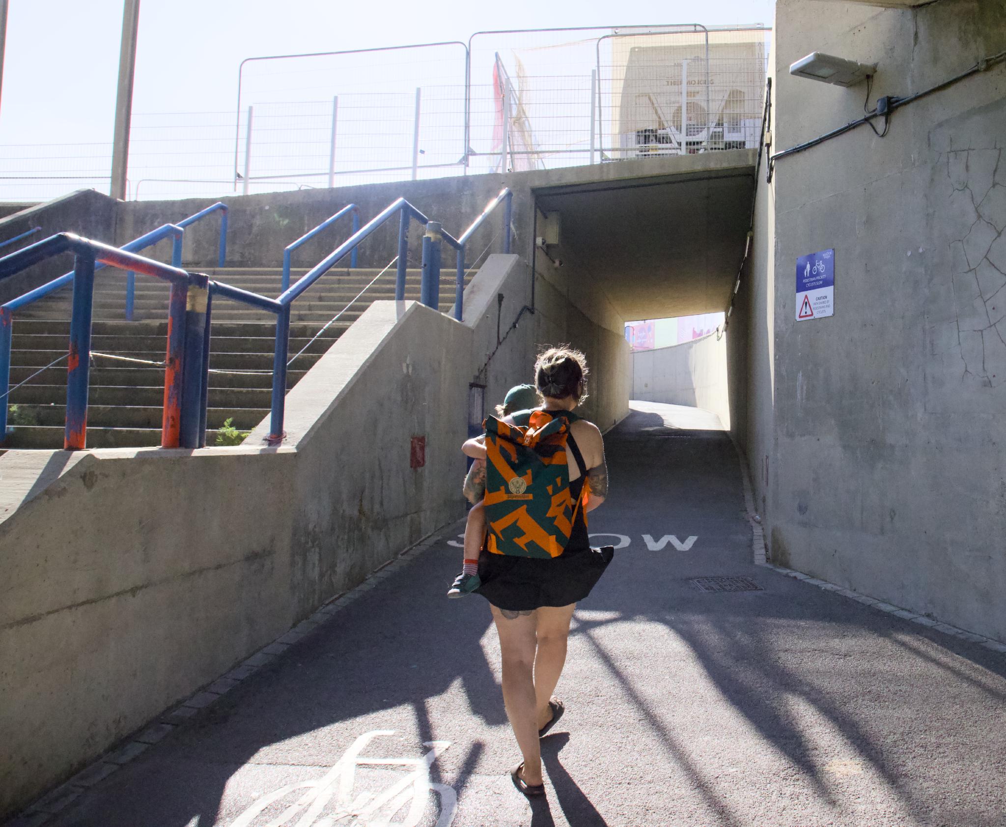 Nadine carrying Kellin through the underpass towards the seafront