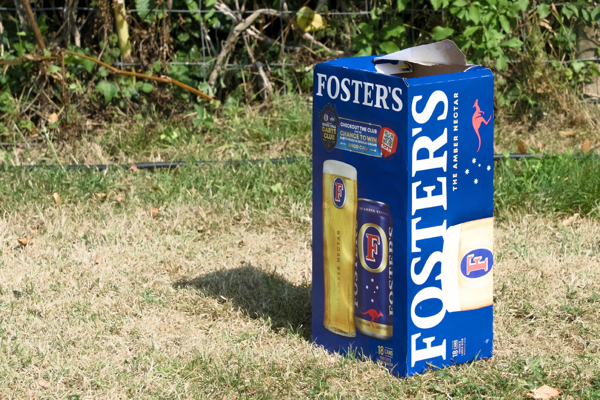 Foster's 18-can box standing on dry grass