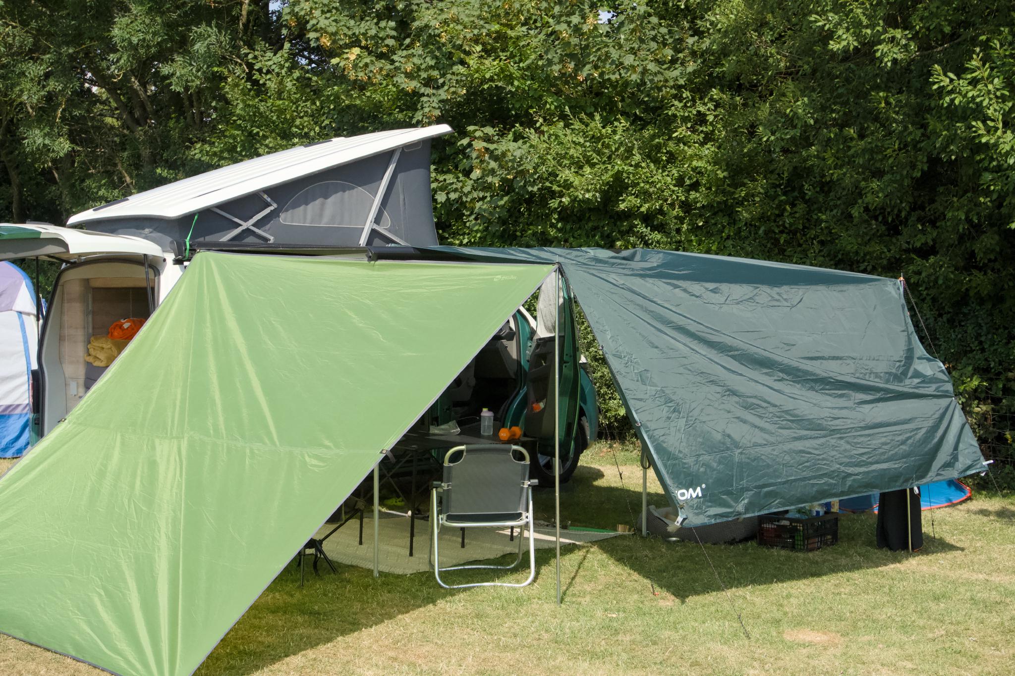 California with the roof up and a tarp shelter built next to it, pop-up tent behind