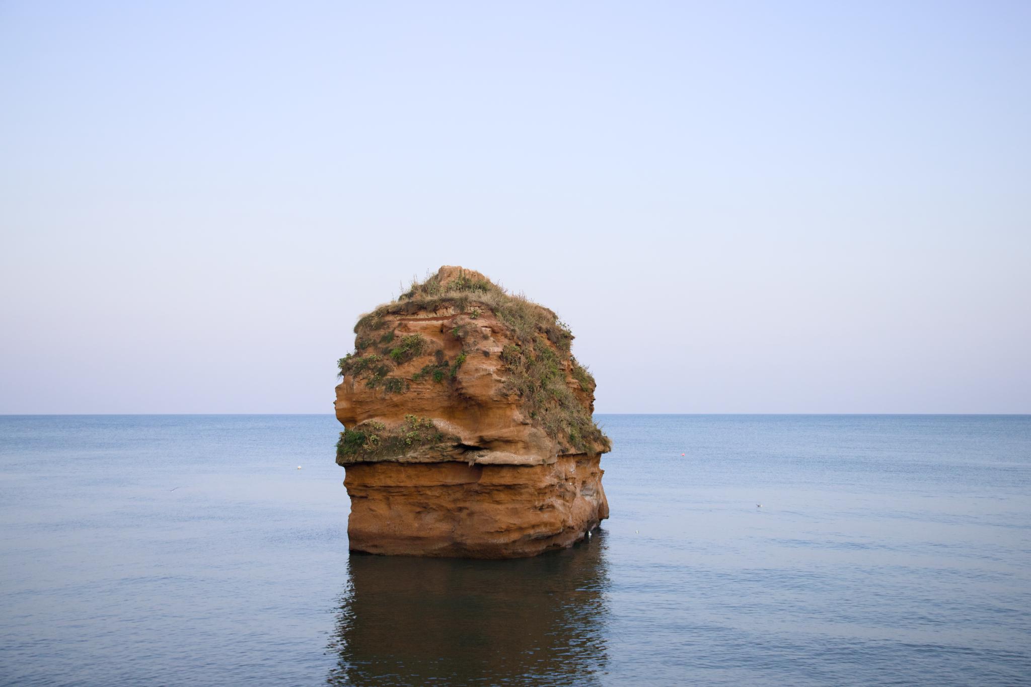 Red sandstone sea stack in a calm sea