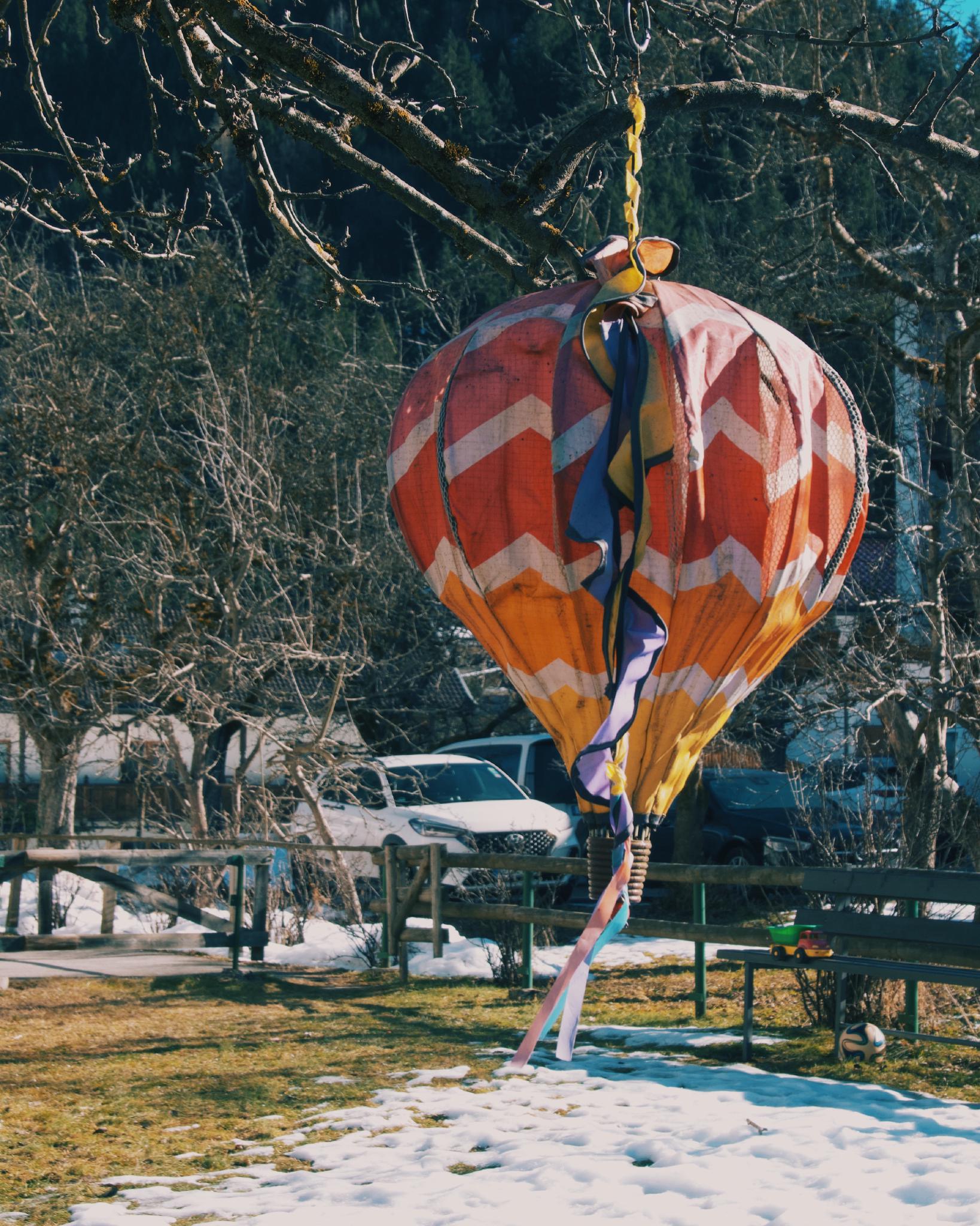 Colorful small hot air balloon stuck in a tree