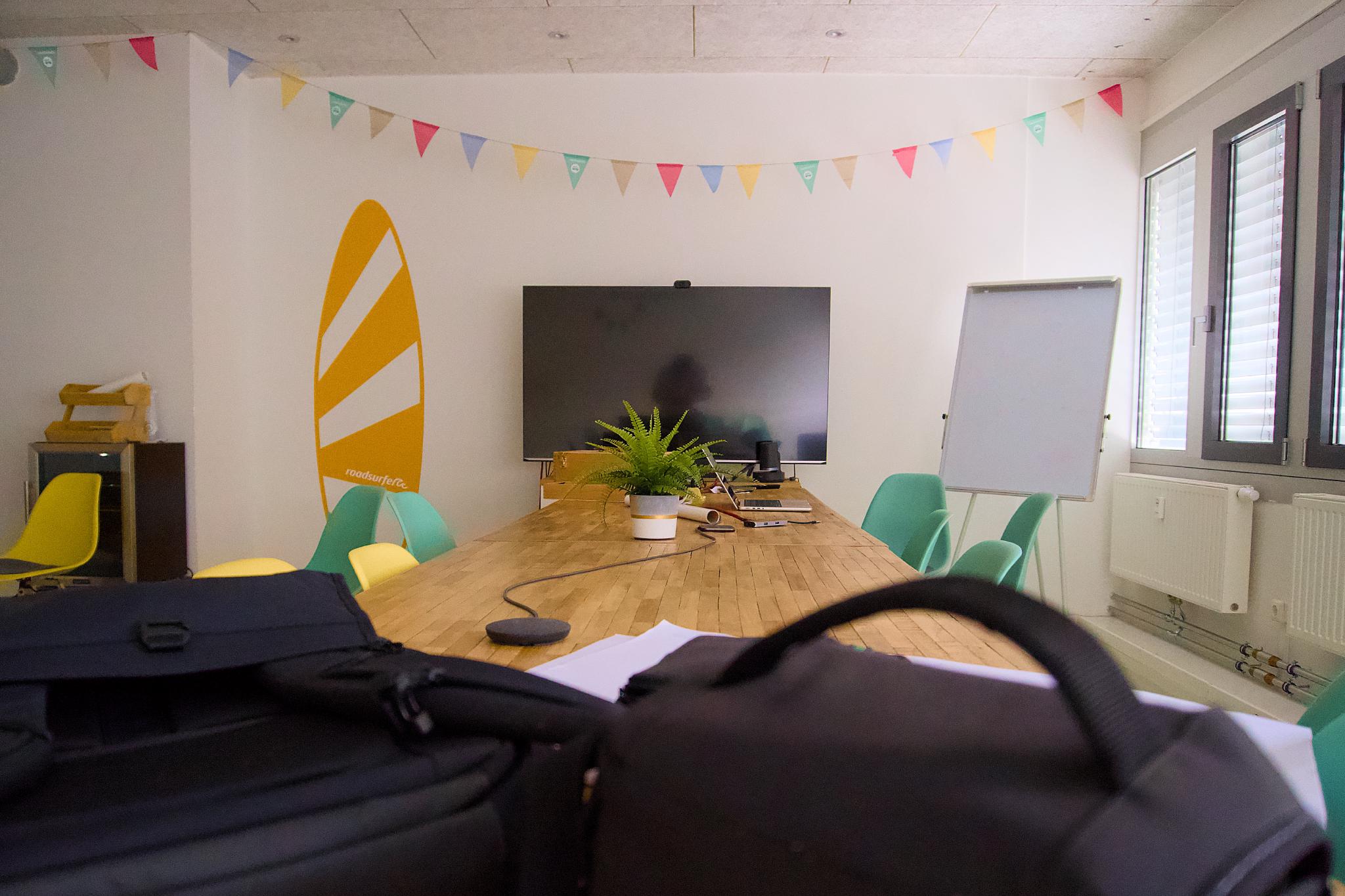 Meeting room at roadsurfer HQ with a surfboard wall graphic and bunting